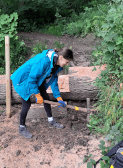 With the steps and railing in place, Contours use a mattock to clear the remaining undergrowth and make the new crossing accessible for all.