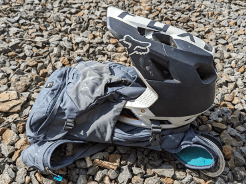 A full-face cycling helmet held securely on the back of a rucksack.
