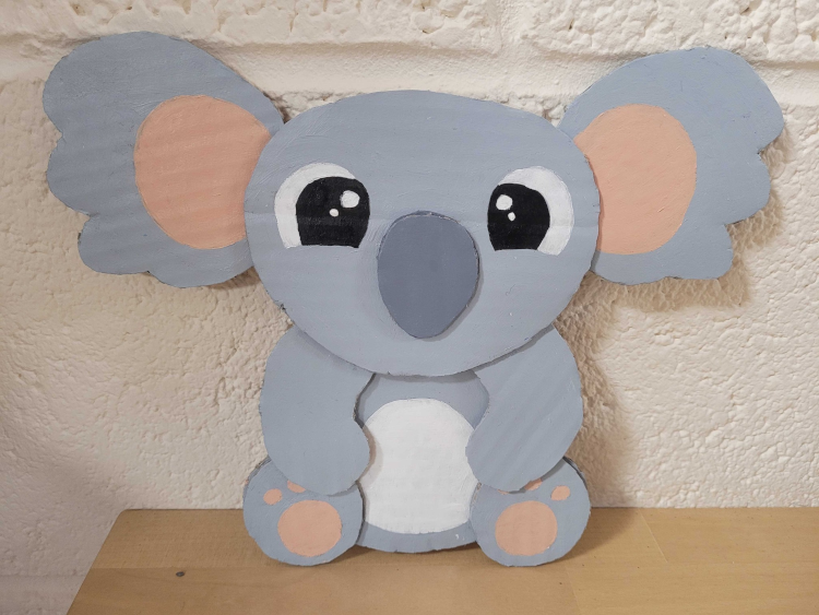 A koala made from cardboard painted grey.