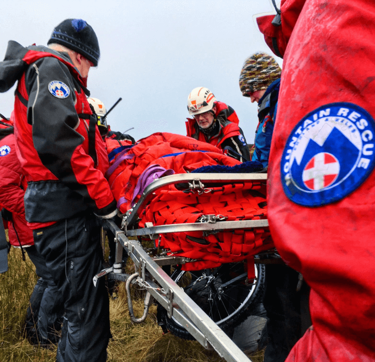 Mountain Rescue carry a stretcher to safety.