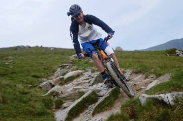 A cyclist tackles slab steps on the Snowdon Ranger Path.