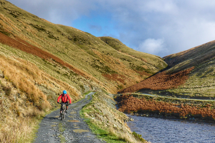 Cycling along a hardpacked grit road alongside a lake